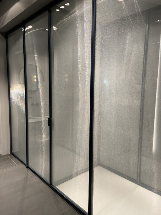 Cabine de douche toute hauteur, collection suite chez Vismaravetro. Paroi en verre securiplus reeded et profilés en aluminium noir.