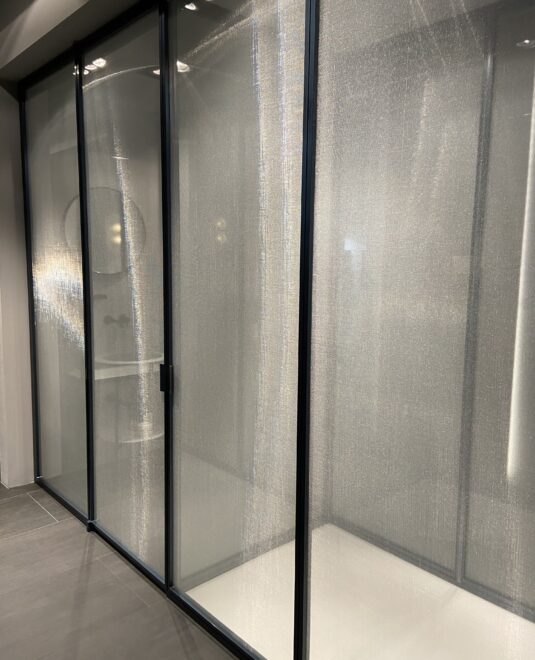 Cabine de douche toute hauteur, collection suite chez Vismaravetro. Paroi en verre securiplus reeded et profilés en aluminium noir. 