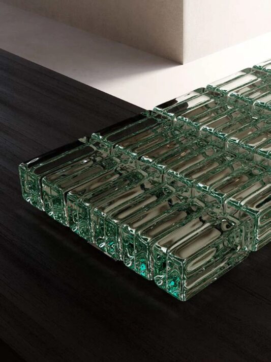 Chaque brique est façonnée à la main dans un moule artisanal, puis résinée avec minutie, créant un jeu de transparences et de reflets. Chez Hydropolis