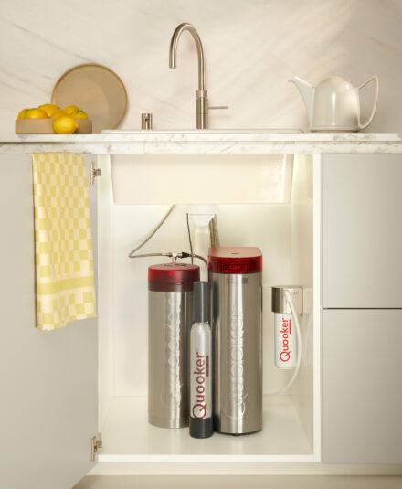 Installation sous évier du réservoir Quooker PRO3 et du module CUBE. Ce système compact permet d'avoir eau bouillante, fraîche, plate et pétillante sans encombrer le plan de travail. À découvrir chez Hydropolis
