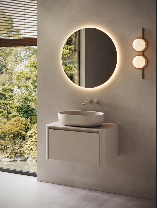 Meuble sous-vasque FUSE avec 1 tiroir, finition laquée mate Dune 236. Plan de travail FUSE et vasque à poser Prime60, finition UHS Dune 236. Miroir rond STRATO avec éclairage LED. Chez Hydropolis