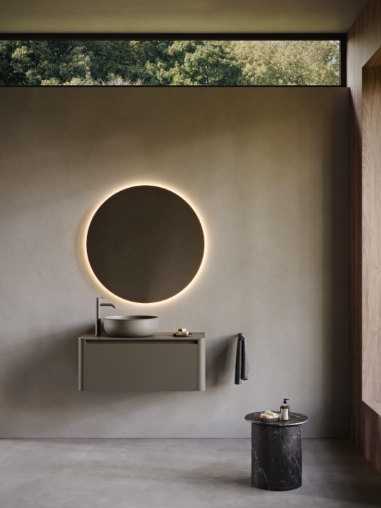 Meuble sous-vasque FUSE avec 1 tiroir, finition laquée mate Forest 239. Plan de travail FUSE et vasque à poser Prime45, finition UHS Forest 239. Miroir rond STRATO à éclairage LED. Robinet mitigeur CODE, finition Forest Matt 239. Porte-serviettes mural EDGE. Tabouret EDGE en marbre Marquina. Chez Hydropolis