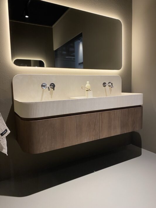 Ella est une réinterprétation du lavabo classique en pierre, où tradition et modernité se rencontrent. Chaque détail a été soigneusement pensé pour une harmonie parfaite entre forme et fonction. Plan de travail avec vasque intégrée en marbre beige, meuble haut 1 tiroir.